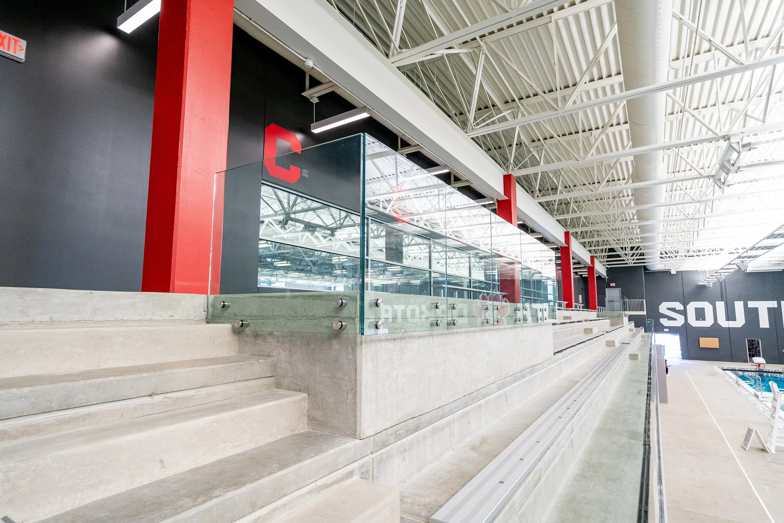 Usd Natatorium Wellness Center 09526 Lower angle perspective of precast steps with red accent column and Coyote branding.