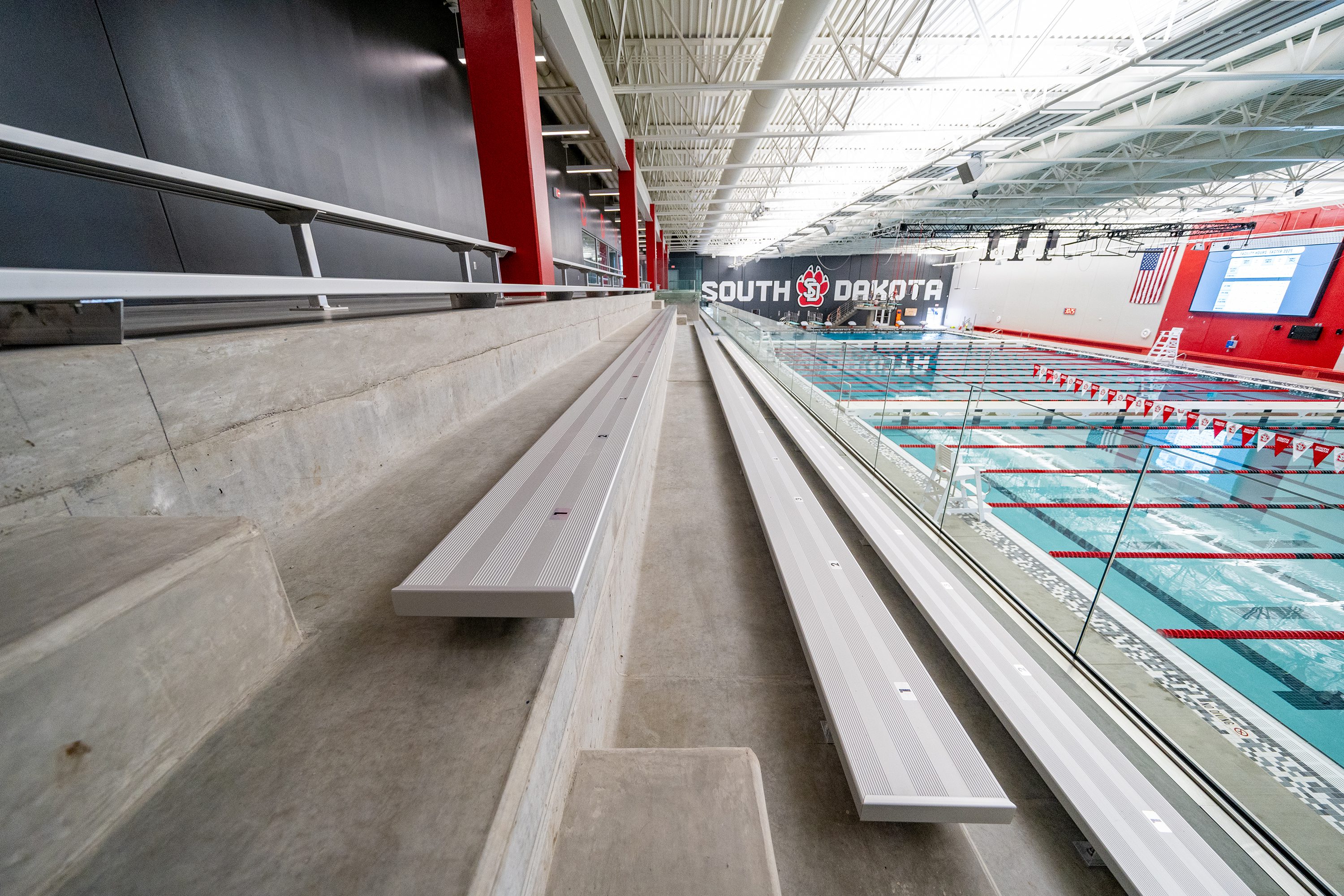 Bleacher-level angle of precast stadia showing aluminum bench seating and railing.